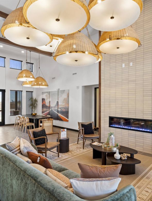 Mesa Vista Affordable Apartments with Modern lobby with cozy seating, large hanging lights, a fireplace, and artwork on the walls.